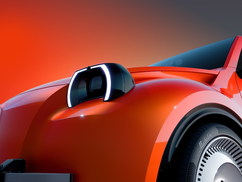 Détail de la carrosserie orange du Citroën 2CV concept autour d’un élément circulaire