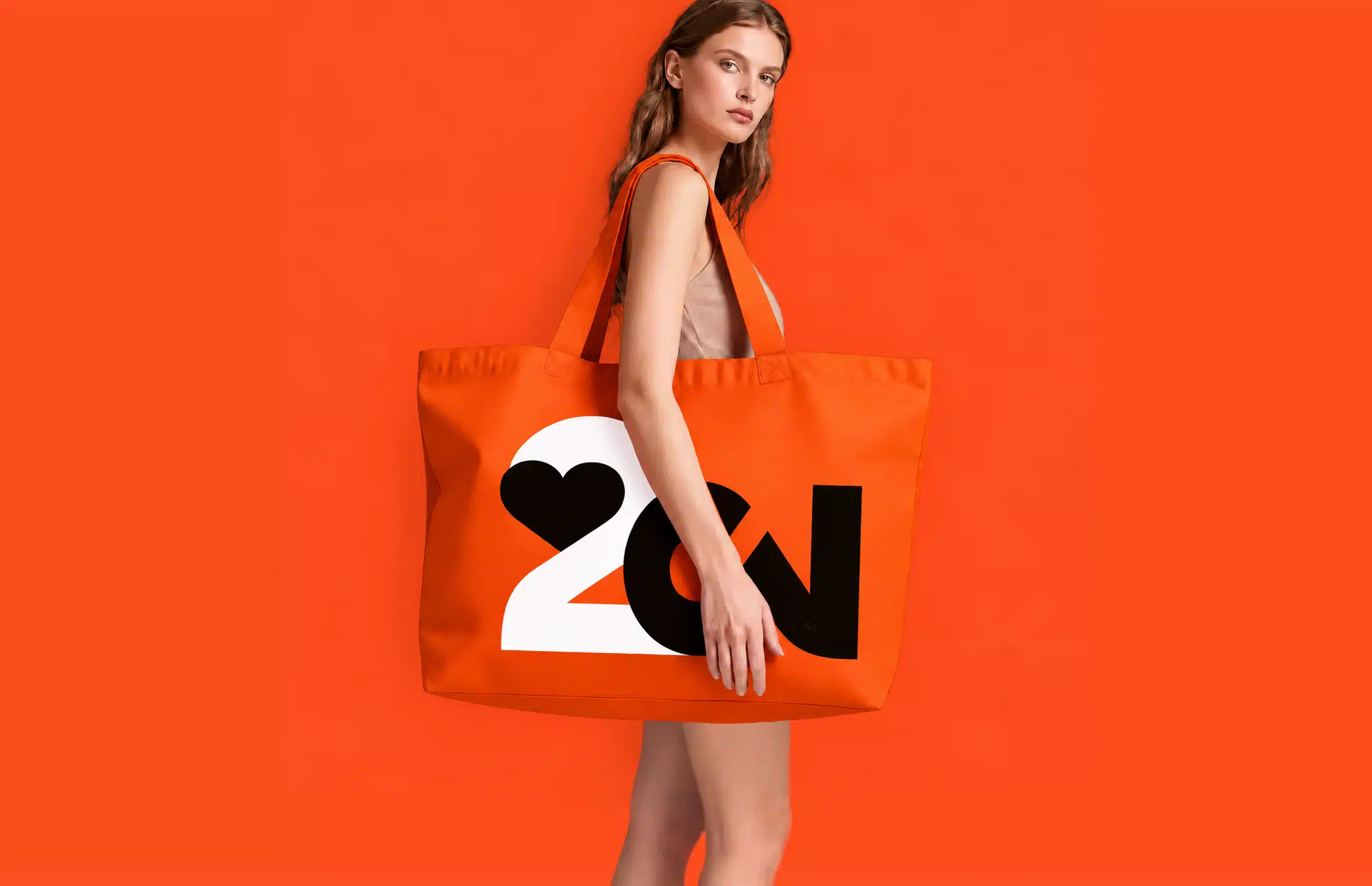 Person carrying a large orange tote bag with a black and white 2CV-inspired graphic against a red background